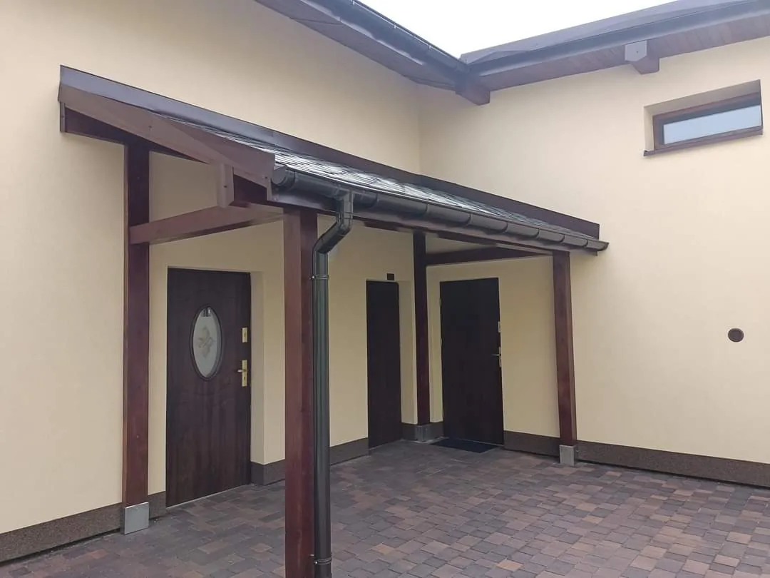 Drewniane zadaszenie wejścia do domu z rynną